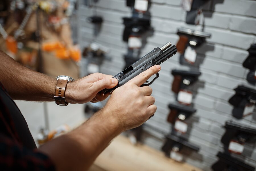 man-choosing-new-handgun-showcase-gun-shop